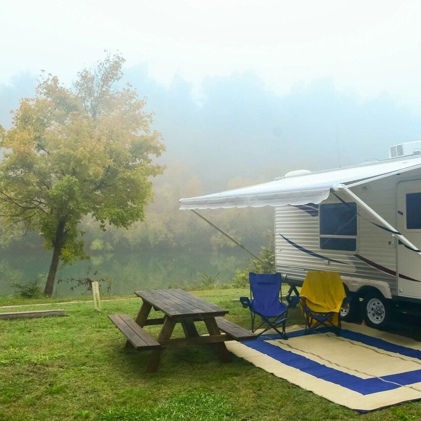 RV-with shade-and-table-while-misty-weather